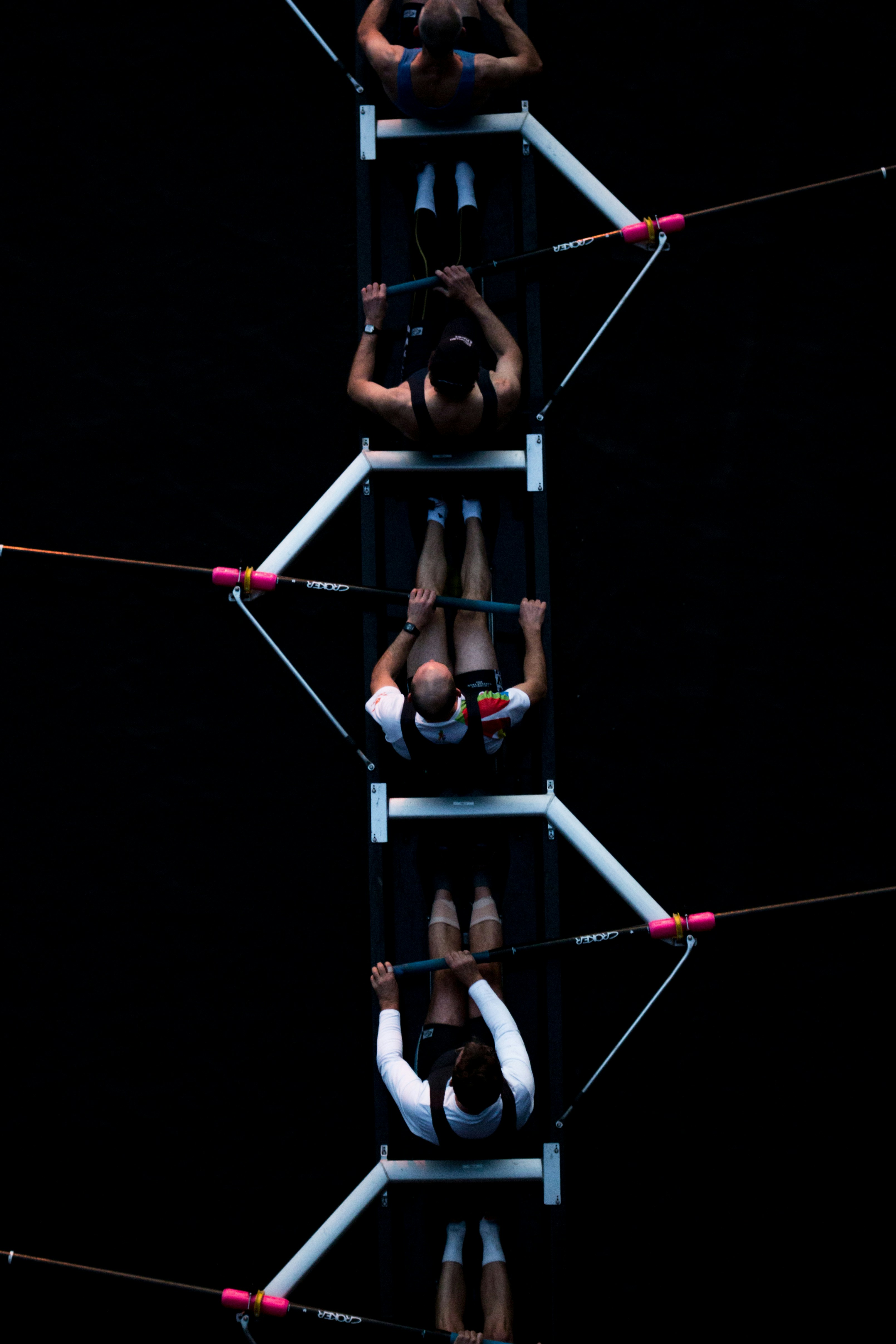 An aerial view of a rowing team paddling in unison.